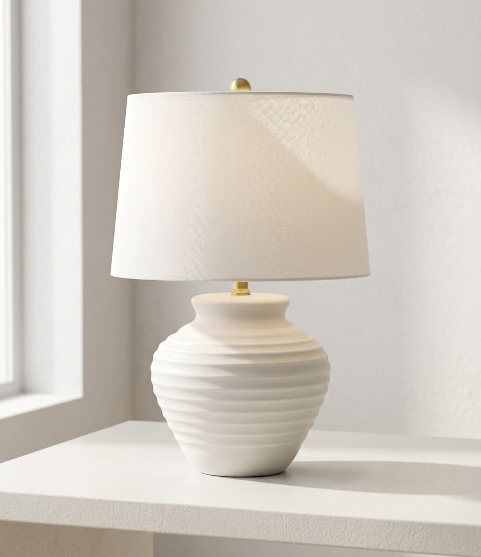 Warm white ceramic table lamp rated 2700K on a nightstand casting soft light